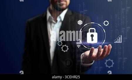 Modern cybersecurity concept with a businessman presenting a digital lock symbol in a high-tech environment Stock Photo