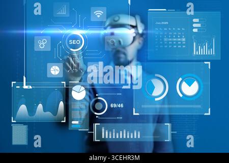 Man interacts with virtual data dashboard wearing VR headset in a modern office setting in the year 2025 Stock Photo