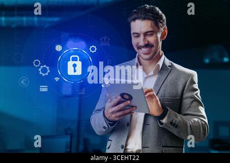 Man in business attire engages with tablet displaying digital security interface in modern office environment Stock Photo