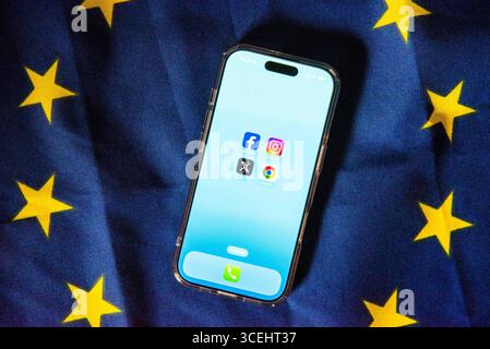 29 July 2025, Belgium, Brüssel: The logos of Facebook, Instagram, X (formerly Twitter) and Google Chrome can be seen on the screen of a smartphone resting on an EU flag. The European Union is making large online platforms and browser providers more accountable with laws such as the Digital Services Act (DSA) and the Digital Markets Act (DMA). Photo: Alicia Windzio/dpa Stock Photo