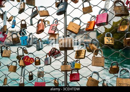 Many locks or padlocks hung and locked on a wire fence in a city in Europe. Close up shot, urban couples tradition concept, shallow depth of field, wa Stock Photo