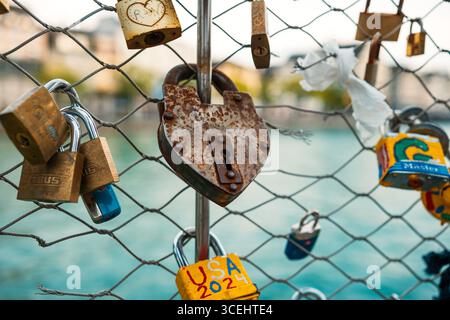 Many locks or padlocks hung and locked on a wire fence in a city in Europe. Close up shot, urban couples tradition concept, shallow depth of field, wa Stock Photo
