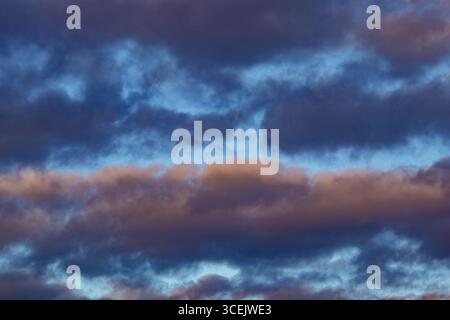 Colorful evening clouds with shades of purple and orange in a twilight sky Stock Photo