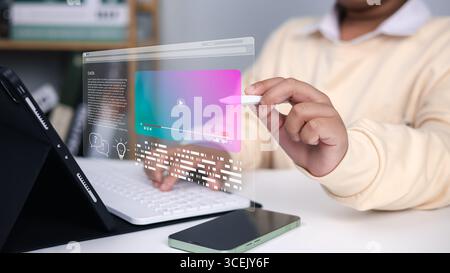 Online learning, education technology, innovation, and future digital interface in modern classroom. Boy using digital pen with holographic screen and Stock Photo