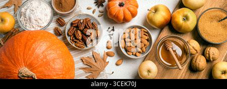 Autumn fall baking background with pumpkins, apples, nuts, food ingredients and seasonal spices, long banner format. Cooking pumpkin or apple pie for Stock Photo