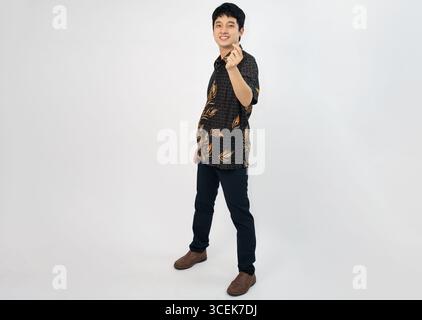 young office man wearing traditional batik posing cheers with confidence Stock Photo
