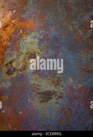 abstract background backdrop or wallpaper of oxidized metal with shapes and patterns of rust color green grey purple orange and blue grunge colors Stock Photo