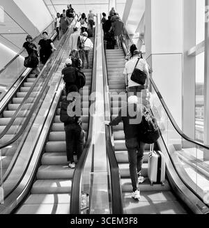 Escalator at Laguardia Airport, New York, 2025, going up with many people. Stock Photo