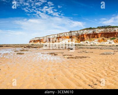 A colourful seascape featuring the brown sand and rugged cliffs at Hunstanton in Norfolk. Stock Photo