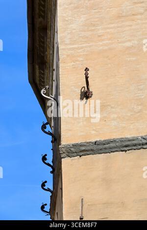 203 Artistic shutter tiebacks in a row on the wall of a house at the corner of Piazza San Giovanni Square and Via dei Pellegrini Street. Siena-Tuscany Stock Photo