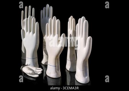 White plaster hands on a black background. Stock Photo