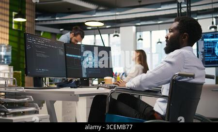 Computer scientist with paraplegia in office automating repetitive tasks with AI scripts. IT professional in wheelchair using artificial intelligence to speed up feature implementation, camera A Stock Photo