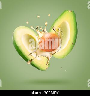 avocado with oil splash on a light green background. Stock Photo