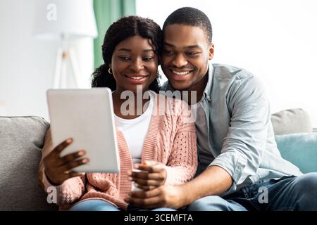 Relaxed african american family using digital tablet together, taking selfie Stock Photo