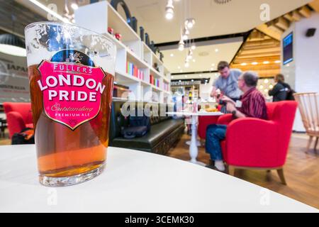 Pint of Fuller’s London Pride premium ale on table inside London’s Pride by Fuller’s restaurant on the first day of operation of the new Queens’s Term Stock Photo