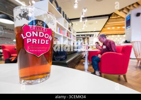 Pint of Fuller’s London Pride premium ale on table inside London’s Pride by Fuller’s restaurant on the first day of operation of the new Queens’s Term Stock Photo