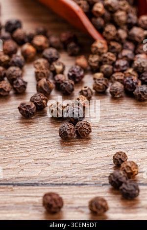 Black Peppercorns on Wooden Table with Copy Space - Rustic Culinary Background Stock Photo