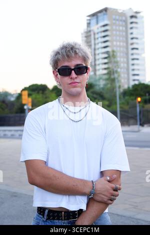 Portrait of a caucasian young man looking at camera seriously standing in urban street. Stock Photo