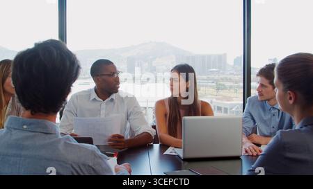 Businessman Team Using Laptops Having Meeting Sitting Around Boardroom Table Together Stock Photo