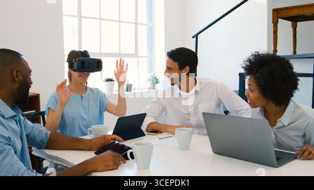 Multi-Cultural Business Team With Laptop And Virtual Reality Headset Having Meeting In Office Stock Photo