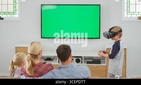 Family Playing Computer Game Using Virtual Reality Headset Stock Photo