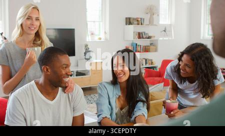 Group Of Young Multi Cultural Friends Chatting And Drinking Coffee In Kitchen At Home Together Stock Photo