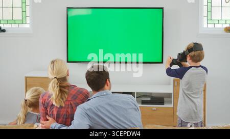 Family Playing Computer Game Using Virtual Reality Headset Stock Photo