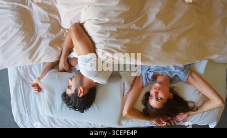 Overhead View Of Couple With Relationship Problems Lying In Bed Stock Photo
