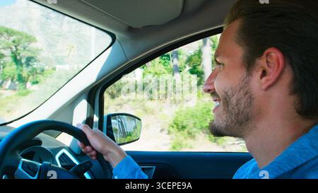 Close Up Interior View Of Young Man Driving Car Through Countryside Stock Photo