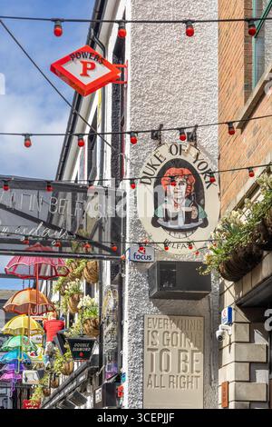 street with hanging umbrellas and a pub Stock Photo