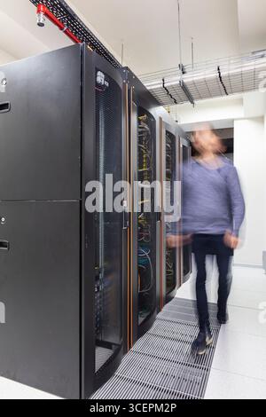 Modern Server Room Data Center with Rows of Server Racks, High-Tech IT Infrastructure, Network Equipment and Advanced Digital Technology Stock Photo