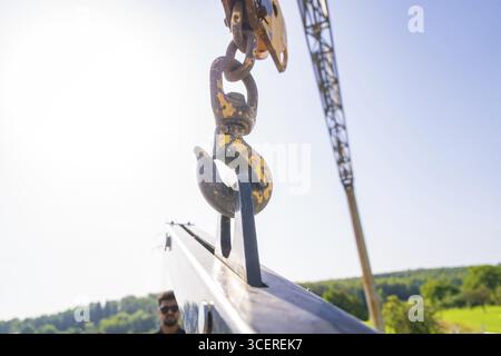 Crane hook with yellowish patina in front of a clear blue sky, PV installation, commercial customers, new building, Wiernsheim, Germany Stock Photo