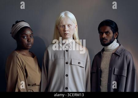 Horizontal medium studio shot of young Black, Caucasian women and Indian man wearing casual clothes looking at camera Stock Photo