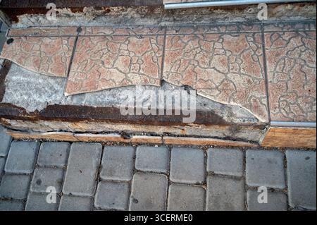 Tiles falling off steps of a store on the street, falling off tiles Stock Photo