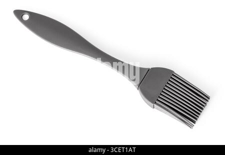 Gray silicone pastry brush lying on a white background, ideal for greasing baking pans or applying glazes Stock Photo