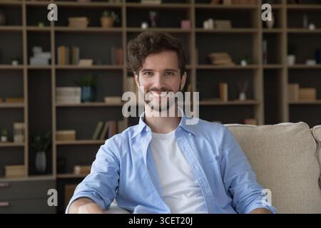 Portrait smiling young male relaxing on couch in living room Stock Photo