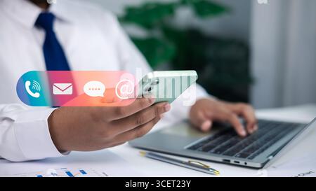 Contact us or email marketing concept, Website page, Customer support hotline, Contact us by mobile online, Businessman sitting and working on compute Stock Photo