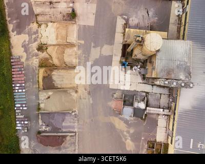 Aerial view of construction material storage yard with silo, sand, and gravel piles Stock Photo