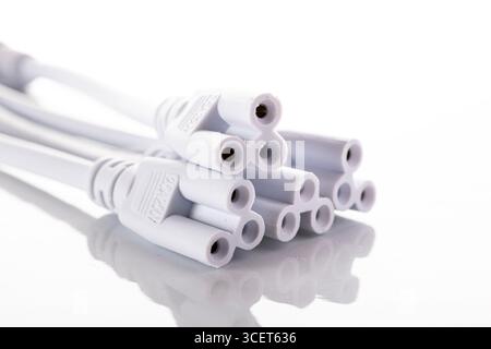 A collection of white connector plugs arranged on a white background. The plugs have multiple ports for connecting various devices. Stock Photo
