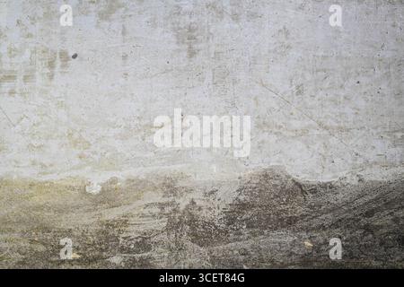 A close-up photo of a textured concrete wall with visible stains, scratches, and weathered marks. The rough surface shows natural patterns and grunge Stock Photo