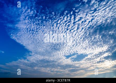 A vast expanse of beautiful altocumulus clouds forms a stunning natural pattern against a vibrant blue sky over the famous Beimen salt fields in Taina Stock Photo