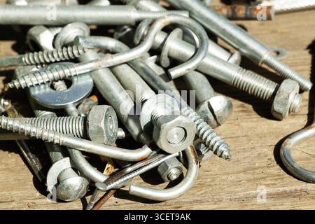 A close-up view of assorted metal fasteners including bolts, screws, and washers.  Stock Photo