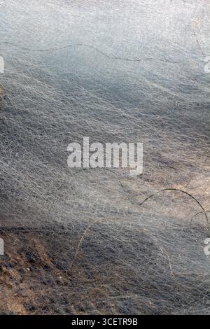 A macro image of fine, overlapping fishing net fibers, displaying a dense, mesh-like texture in subtle blue and brown tones Stock Photo