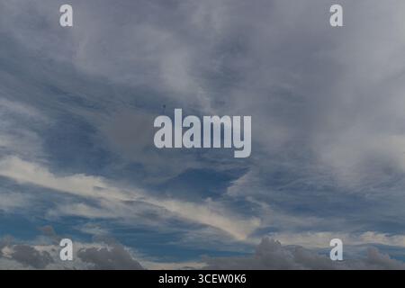 Dramatic cloudy blue sky with soft white streaks and scattered cumulus clouds during late summer afternoon Stock Photo