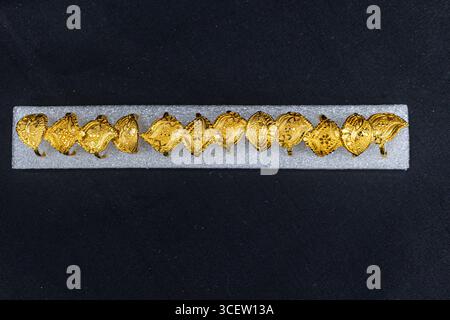 Traditional handcrafted golden rings with embossed patterns displayed on black background Stock Photo