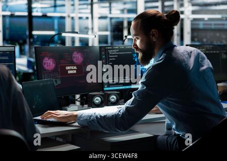 Data center technician using AI LLM assistant to fix critical errors affecting infrastructure. Server hub IT expert using large language model chatbot to eliminate computer bugs Stock Photo