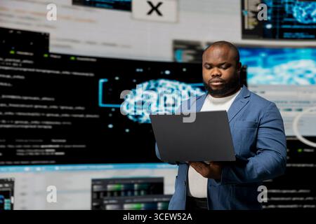 African american professional engineer programming for innovation hub, reviewing big data and binary code on the dashboard. IT developer working on programming language algorithm. Stock Photo