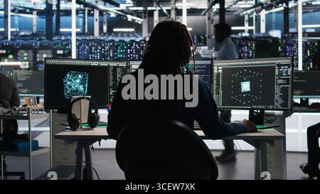 Server room programmer interpreting AI generated data analytics graphs, putting on headphones. Data center IT expert uses artificial intelligence tool showing system metrics, listening music, camera A Stock Photo