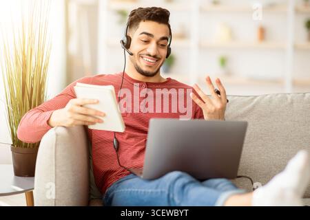 Positive arab guy attending online training from home Stock Photo