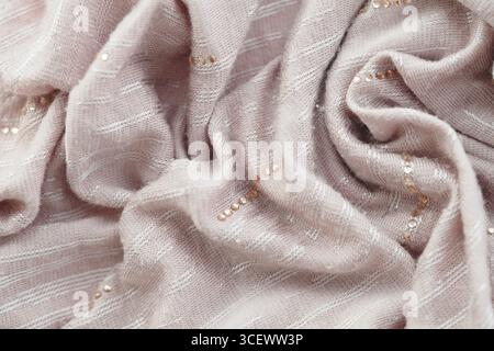 Soft pink fabric draped with delicate embellishments Stock Photo
